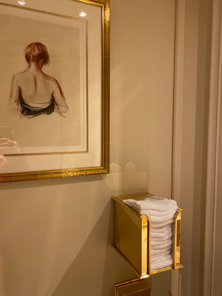 a painting hangs on the wall next to a towel rack