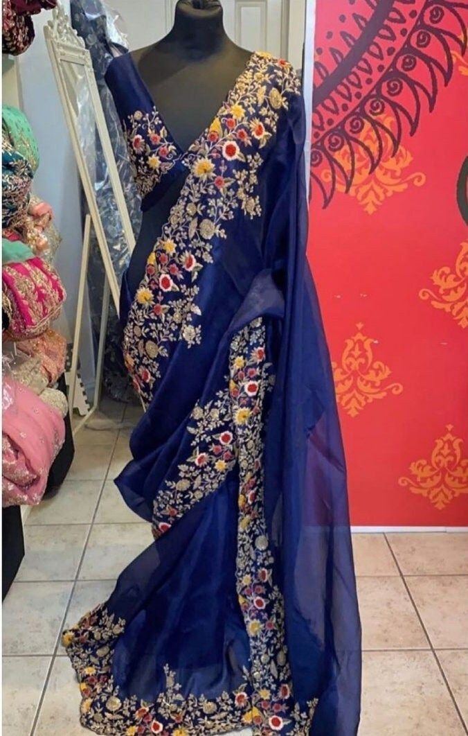 Material in use - Organza silk Color - Navy blue Blouse size - M Saree - 5.5 meter ( all types customization available ) (  All changes  is available at no extra charge like change of color , change fabric and size changes available. ) (( If you need some changes in size, color and fabric. Please use personalize option before order. )) Indian designer outfits for bridal. Made up by 100% hand made. Special designer bridal lehenga choli for  bride made by Bootiwala. Material in use - Dabka,  Nakshi, Kora, Sequins, Zircon, Precious Stone, Glass Beads, Silk yarns, Colorful cotton threads, golden dori, etc. Working technique - Zardozi and Aari work Fabric in use - Raw silk,  taffeta silk,  organza silk,  velvet, Georgette, Net,  cotton,  crepe, chiffon etc. Blue Bollywood Style Pre-draped Tissue Silk Saree, Blue Organza Pre-draped Saree With Pallu, Blue Organza Blouse Piece With Cutdana, Blue Tissue Silk Saree For Party, Blue Tissue Silk Traditional Wear For Party, Blue Organza Pre-draped Saree For Diwali, Blue Traditional Wear With Sheer Dupatta In Tissue Silk, Fitted Organza Saree For Festivals, Blue Embroidered Tissue Silk Blouse Piece