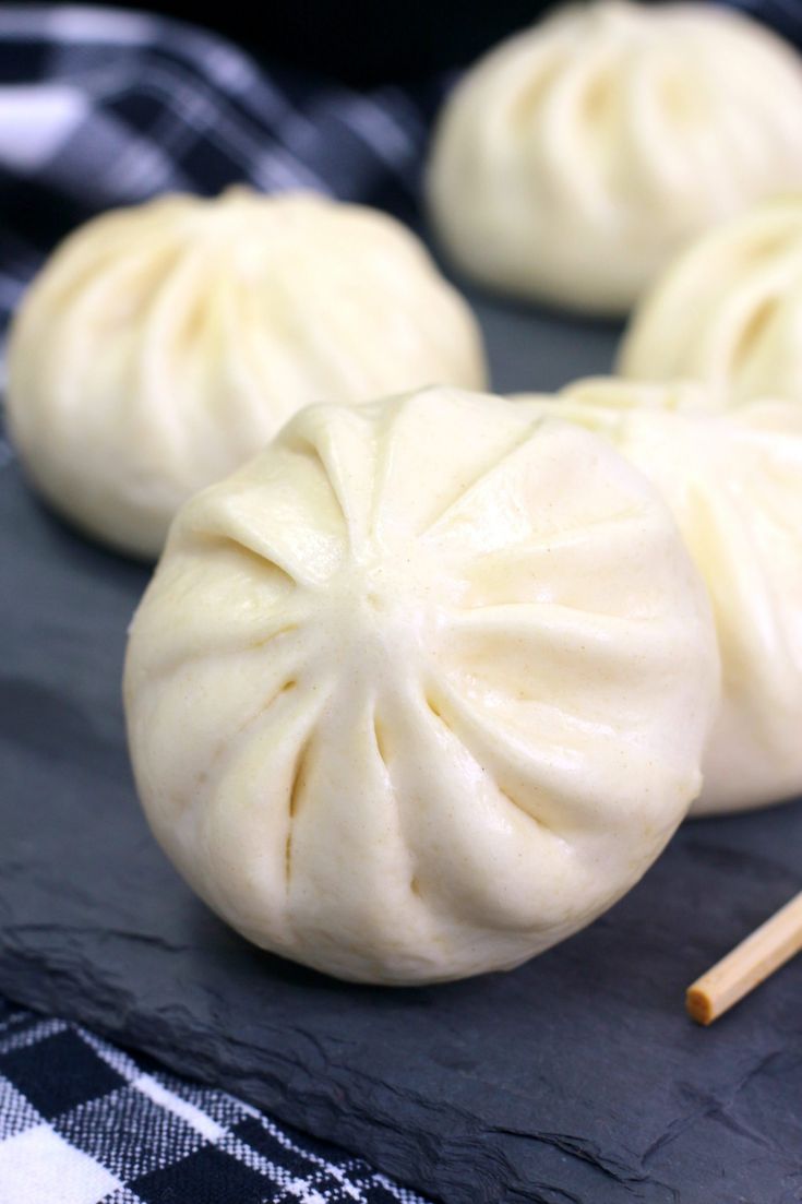 some dumplings are sitting on a table with chopsticks