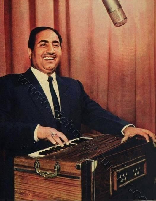 a man in a suit and tie sitting next to an old radio