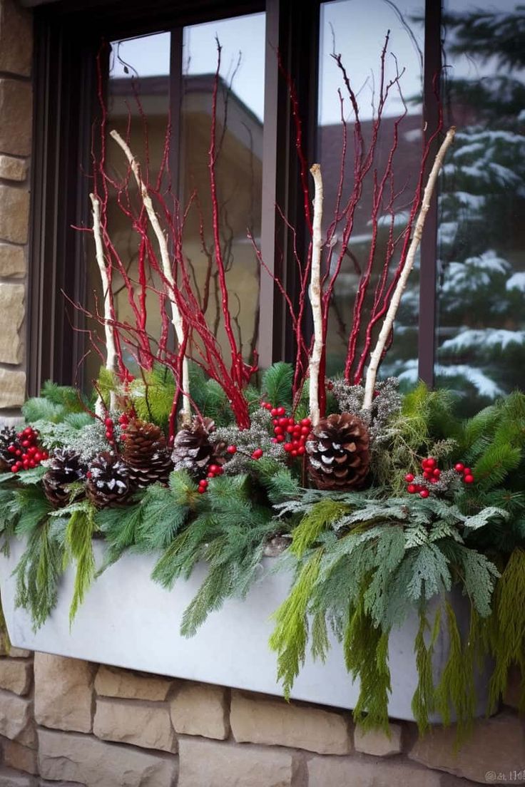 a window sill decorated with evergreens, berries and pine cones