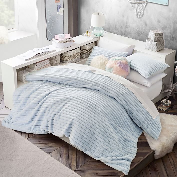 a bed with blue and white comforters in a bedroom