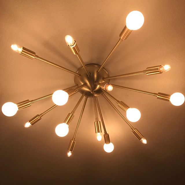 a chandelier with many lights hanging from it's sides and on the ceiling