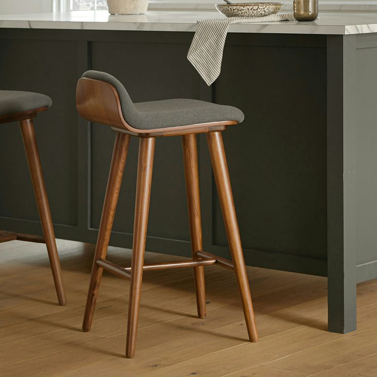 two stools in front of a kitchen island with marble counter tops and wooden legs