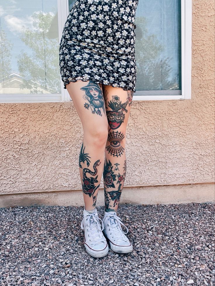 a woman with tattoos standing in front of a window