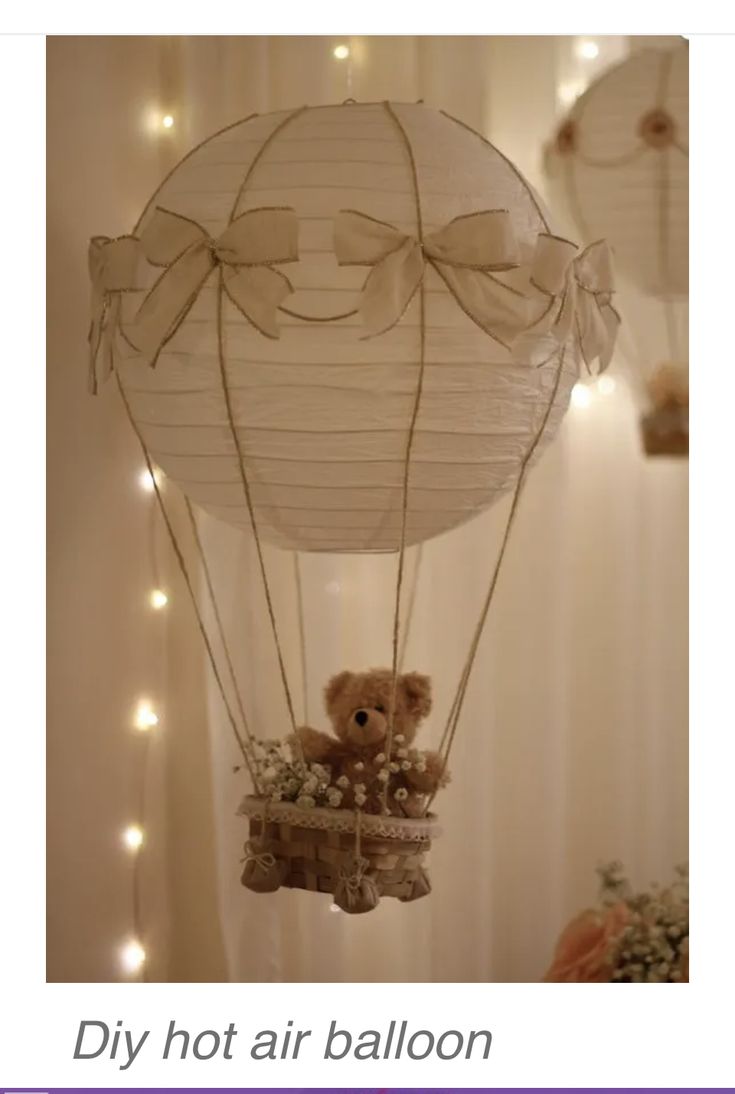 a teddy bear in a hot air balloon with lights on the wall behind it and an advertise that reads diy hot air balloon