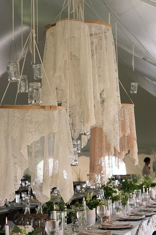 several chandeliers hanging from the ceiling above a table with place settings on it