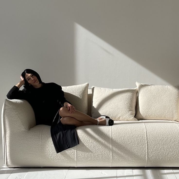 a woman sitting on top of a white couch