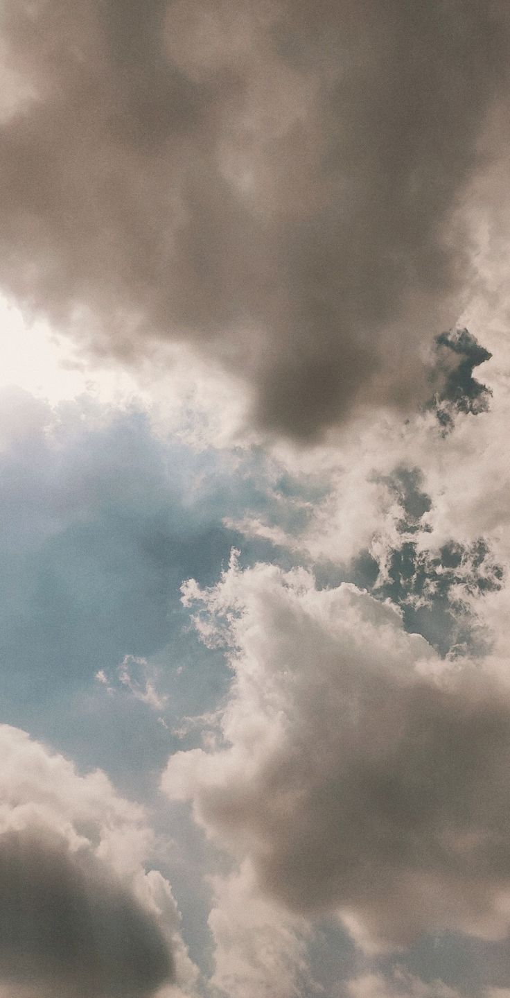 an airplane is flying through the cloudy sky