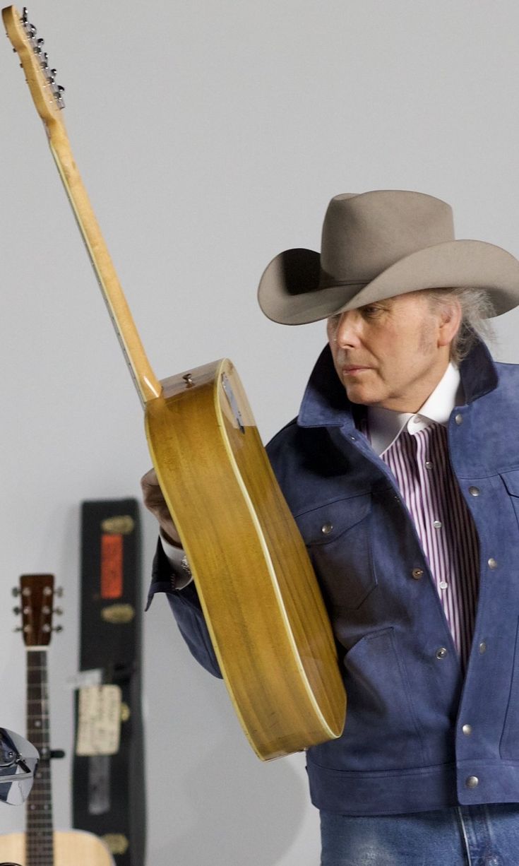 a man in a cowboy hat holding a guitar