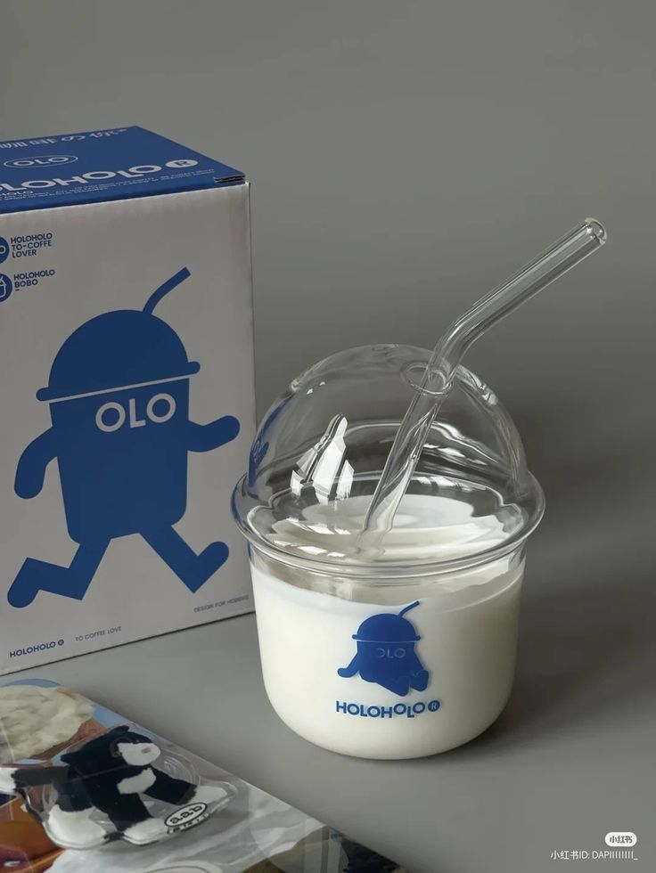 a glass cup filled with yogurt next to a cardboard box