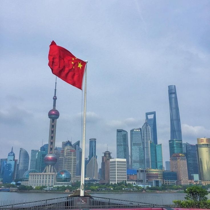 a chinese flag flying in front of the city skyline