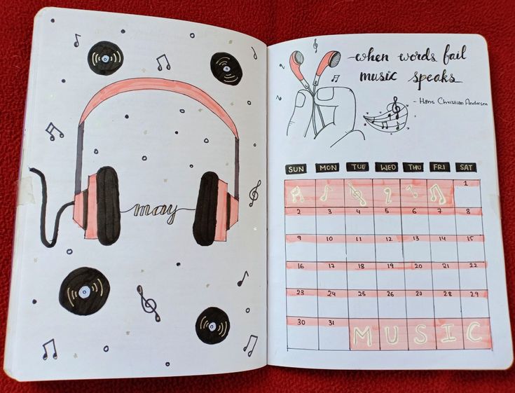 an open planner with headphones on it and music notes in the pages, next to a calendar