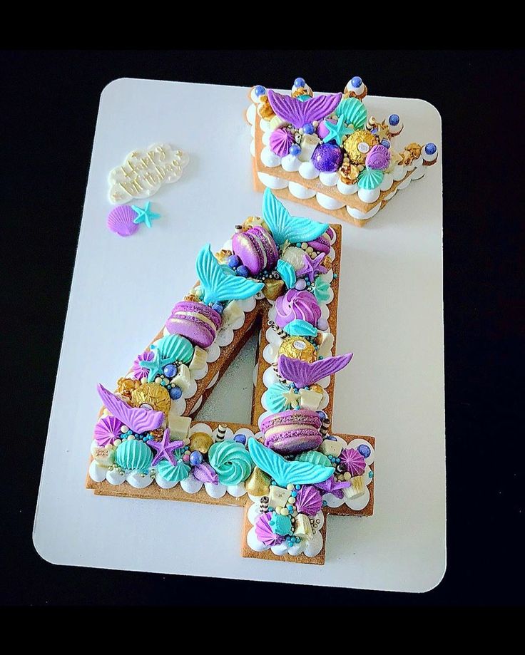 the number four is made out of cookies and decorated with mermaid tail decorations on it