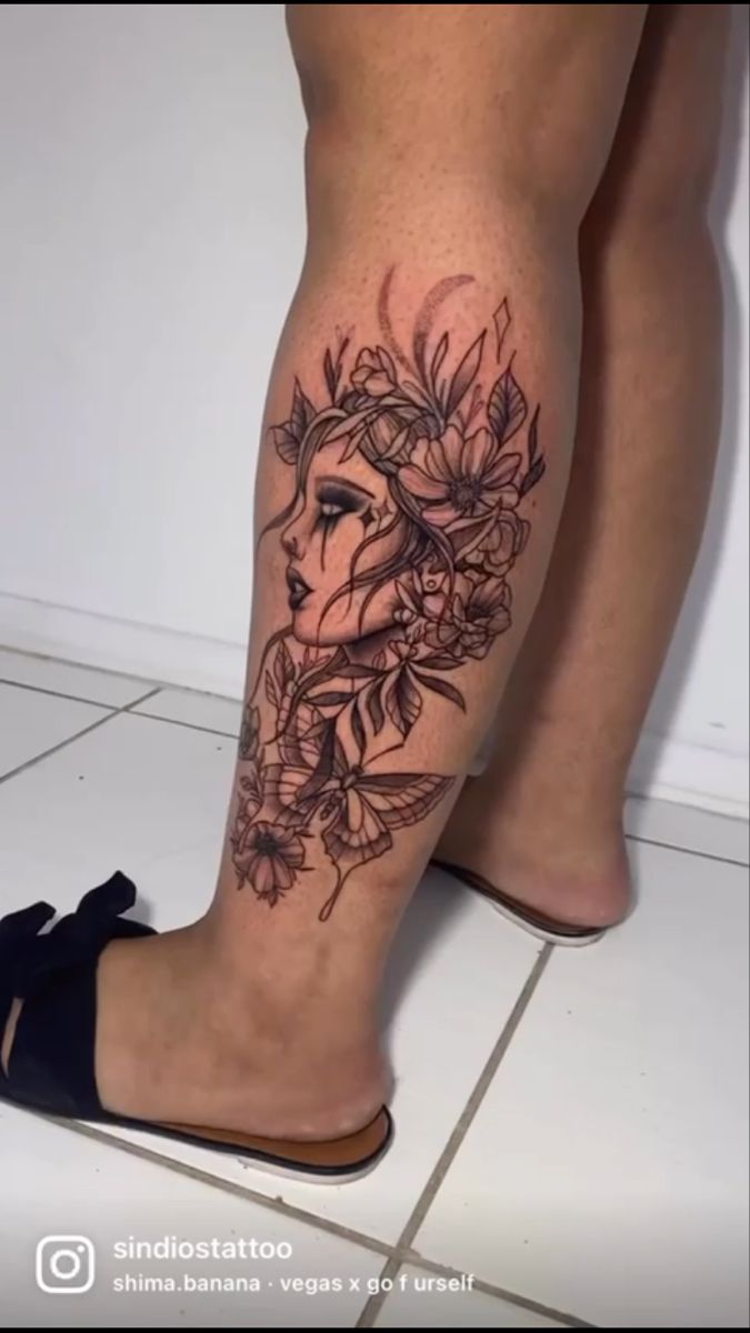 a woman's legs with flowers and a face tattoo on her left calf area