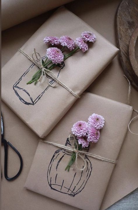 three packages tied up with twine and pink flowers