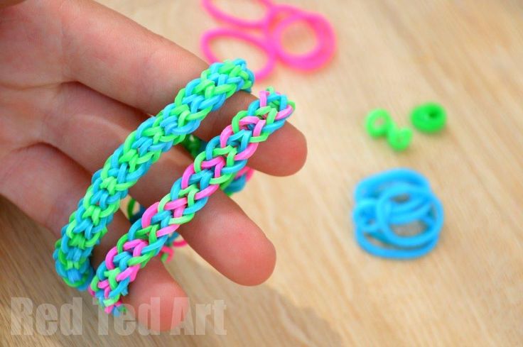 someone is holding some colorful bracelets on a table with scissors and other crafting supplies