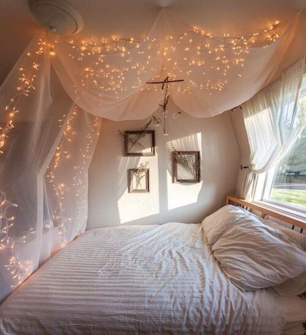 a bedroom with lights strung from the ceiling