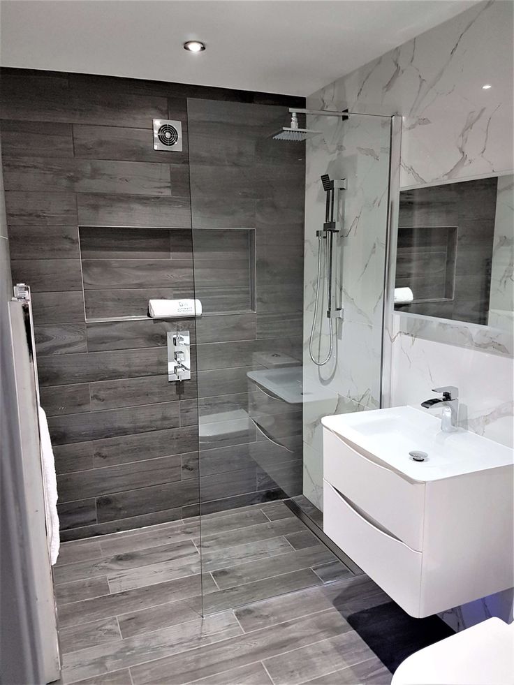 a white sink sitting next to a walk in shower