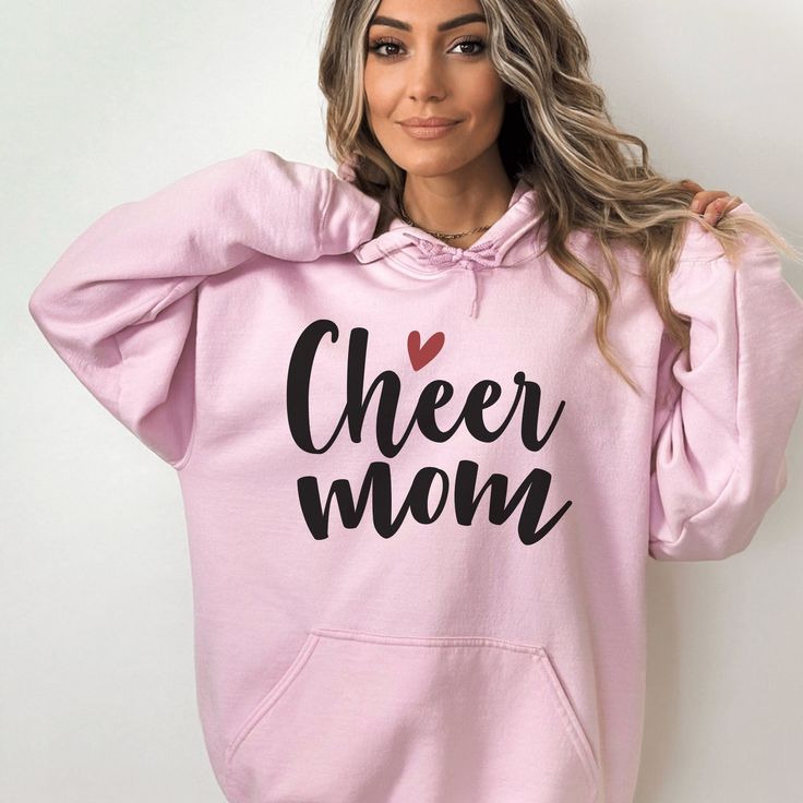 Cheer Mom Hoodie - Show your support in style with this fun and cozy sweatshirt! Featuring "Cheer Mom" in a playful cursive font and a red heart above it, this Gildan 18500 hoodie is perfect for keeping you warm at games and competitions. Made from high-quality materials, this hoodie is comfortable to wear and designed to last. So whether you're cheering on the sidelines or just running errands, make sure to show off your cheer mom pride with this must-have hoodie! ▬▬▬▬▬▬▬▬▬▬▬▬▬▬▬▬FABRIC DETAILS▬▬▬▬▬▬▬▬▬▬▬▬▬▬▬▬This well-loved Gildan 18500 Unisex Hoodie Hooded Sweatshirt is the perfect addition to any collection! The air-jet spun yarn and quarter-turned fabric helps eliminate creases and pilling, while the mix of cotton and polyester creates a soft and comfortable feel.• 50% pre-shrunk cott Casual Slogan Sweatshirt For Mother's Day, Casual Mother's Day Slogan Sweatshirt, Pink Winter Slogan Hoodie, Cotton Hooded Sweatshirt For Mother's Day, Pink Winter Hoodie With Slogan, Winter Pink Hoodie With Slogan, Long Sleeve Hoodie With Letter Print For Mother's Day, Winter Hoodie With Lettering And Long Sleeves, Winter Hoodie Sweatshirt With Lettering