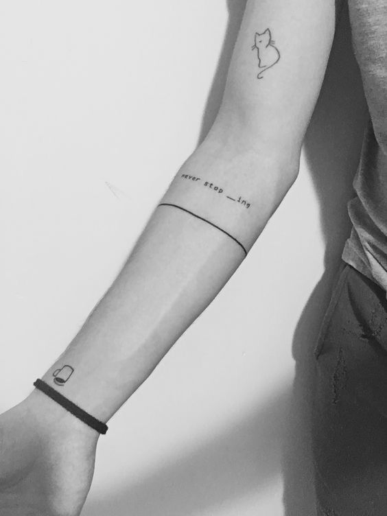 a person with a cat tattoo on their arm and the word love is written below it