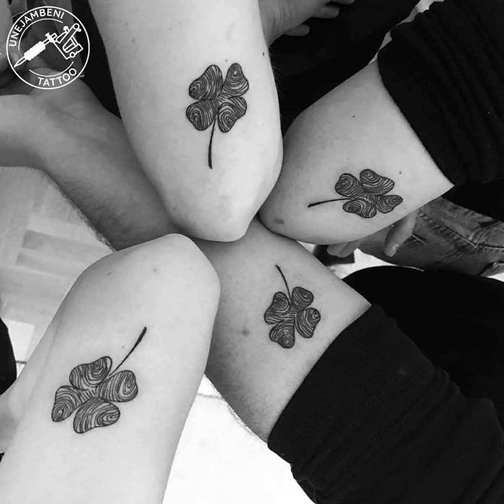 four leaf clover tattoos on the legs and ankles, all in black and white ink