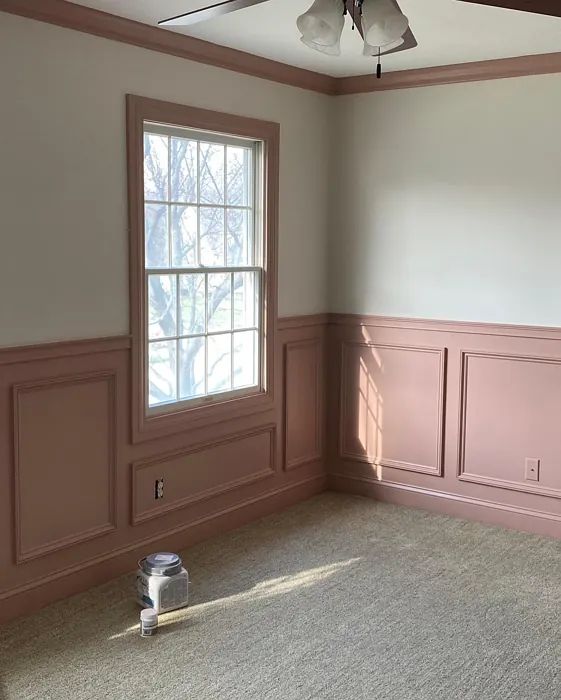 an empty room with pink walls and ceiling fan