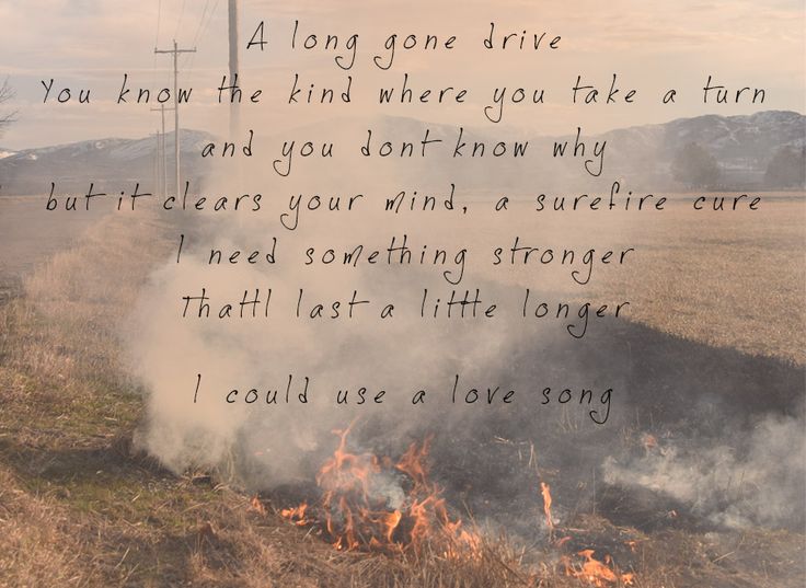 a poem written on the side of a fire in a field with mountains in the background