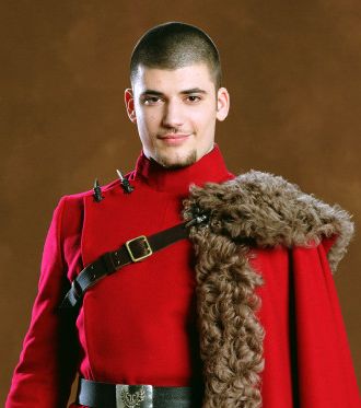 a man in a red uniform is holding a fur hat