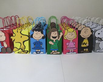 small bags with cartoon characters on them are lined up against a white table and one bag is in the shape of a person