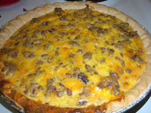 a cheese pizza sitting on top of a metal pie pan covered in meat and cheese