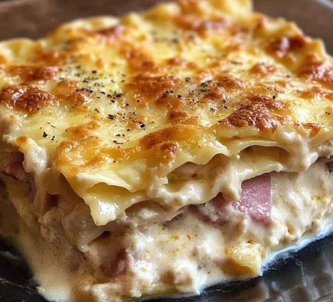 a close up of a casserole dish on a plate with cheese and meat