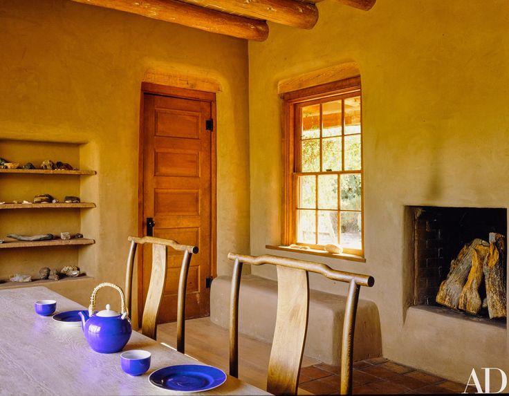 a table with blue plates and cups on it in front of a fireplace