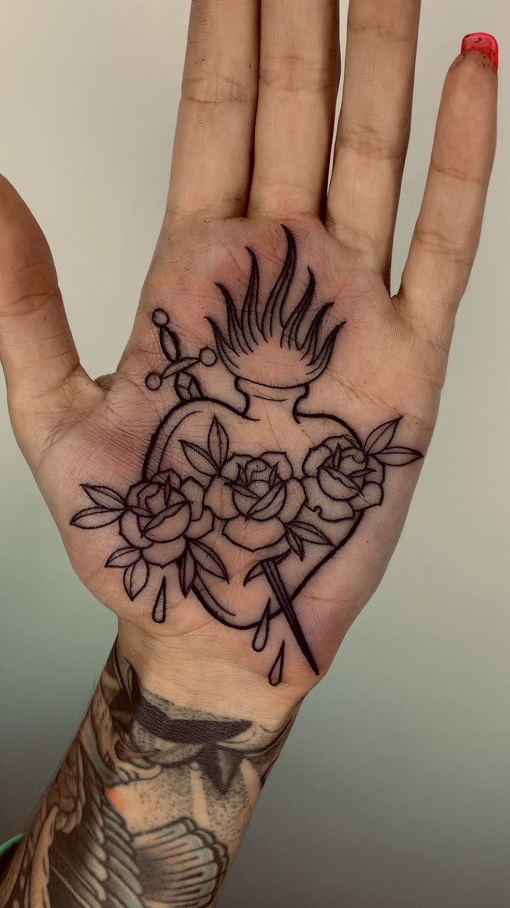 a person's hand with a tattoo on it holding up the palm of their hand