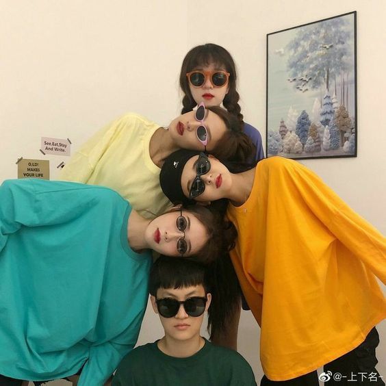 four people with sunglasses on their heads posing for the camera