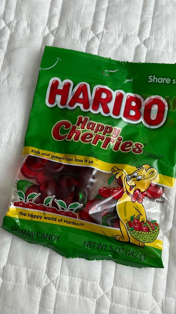 a bag of harbo happy cherries sitting on top of a white bed