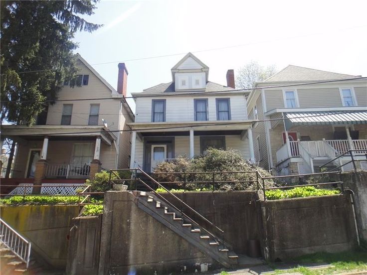 two story house with stairs leading up to the front door