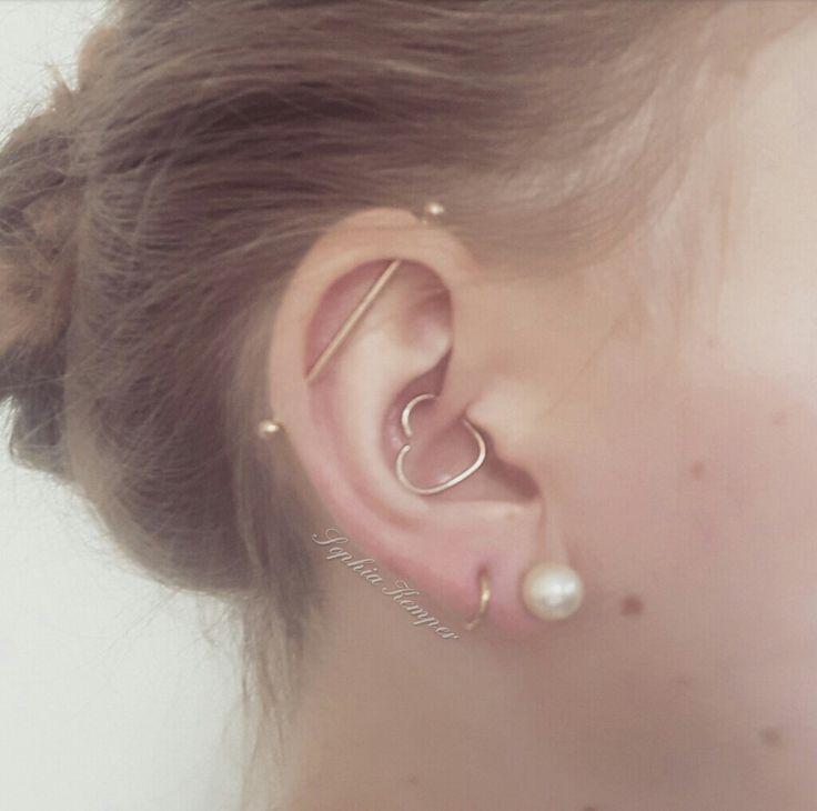 a close up of a person with ear piercings on their ears and behind the ear