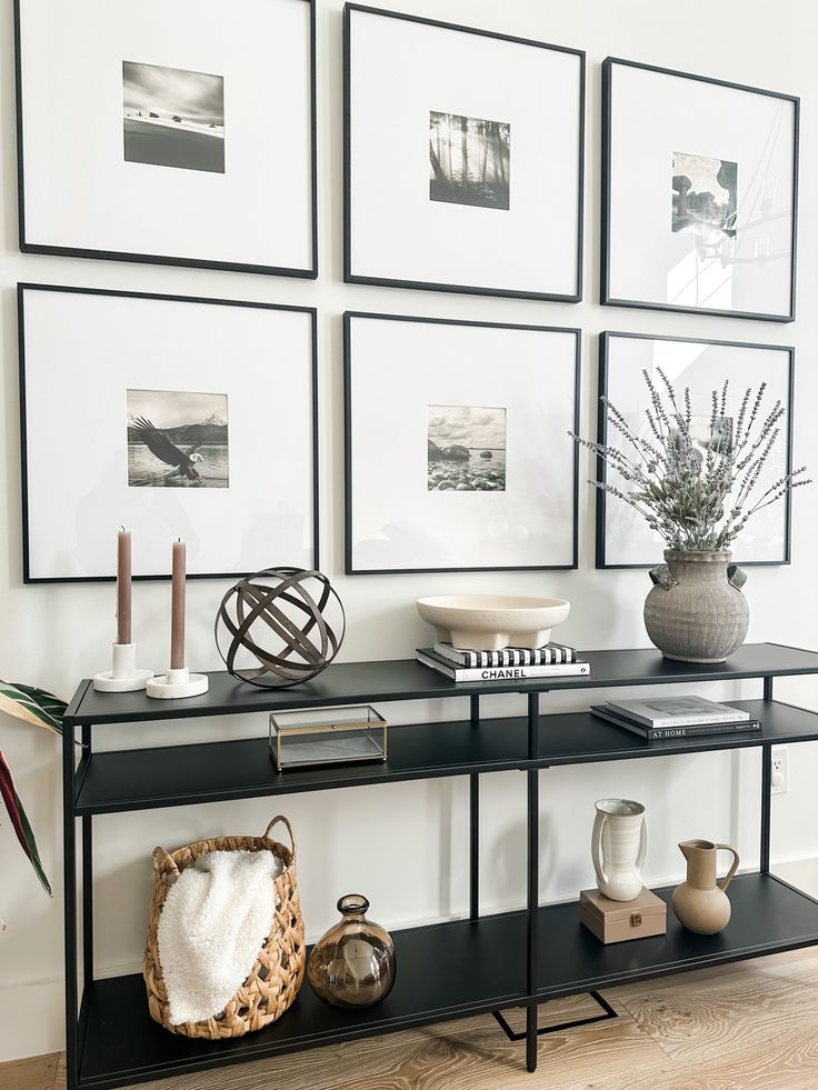 a black table with pictures on the wall behind it and a basket next to it