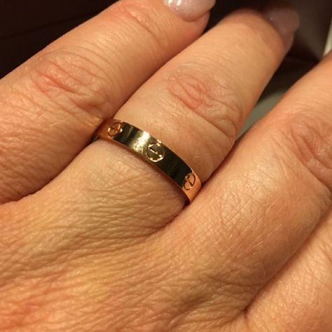 a close up of a person's hand with a gold ring on their finger