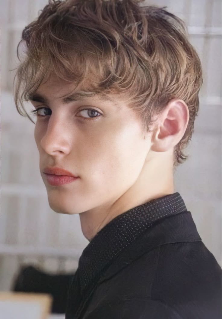 a close up of a person wearing a black shirt and looking at the camera with a serious look on his face