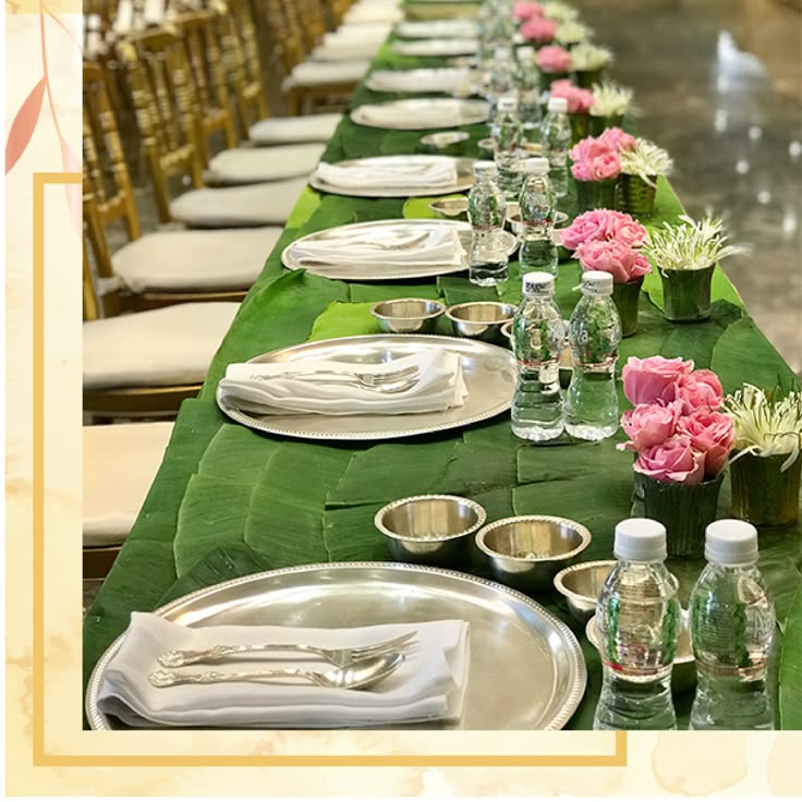 a long table is set with silverware and pink flowers in vases on it