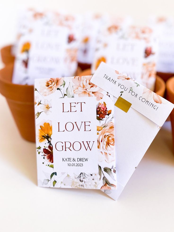 there are many small flower seed packets in the plant pots with tags on them that say, let love grow