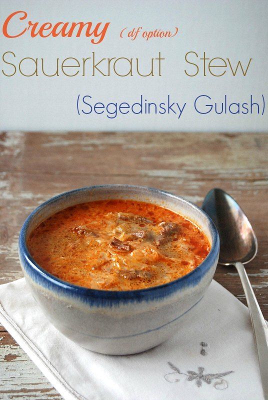 a bowl of soup sitting on top of a white napkin next to a silver spoon