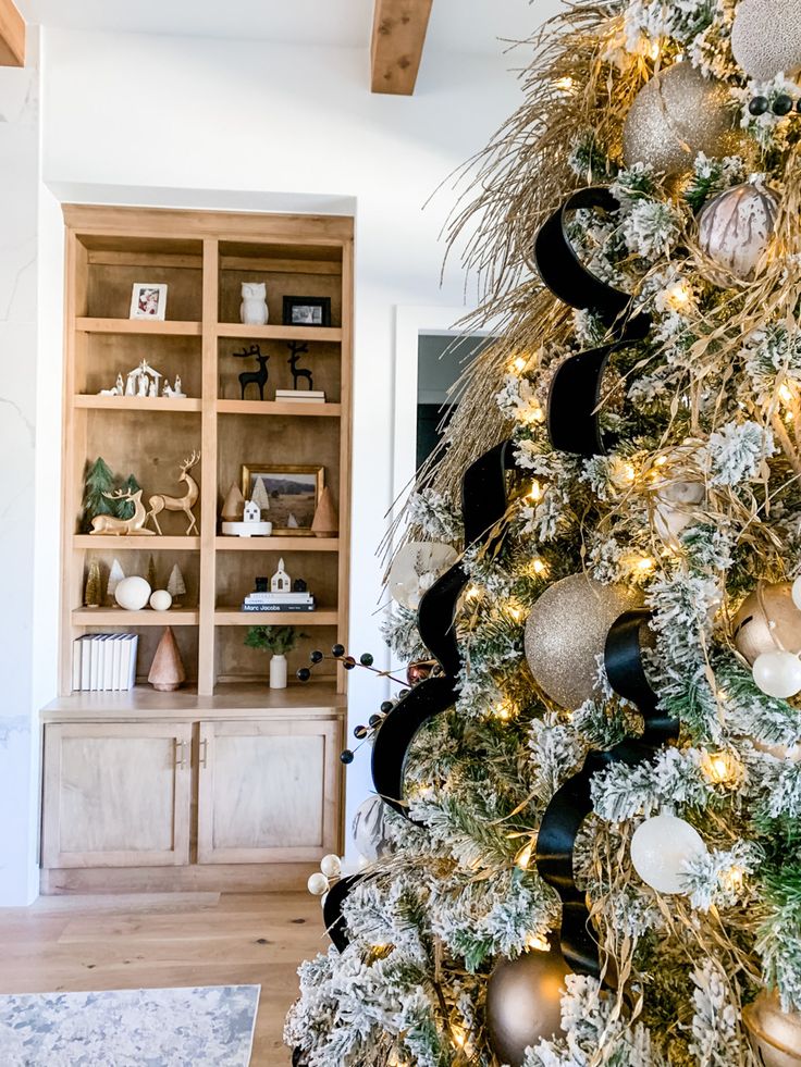 the christmas tree is decorated with gold and black ornaments, while other decorations are arranged around it