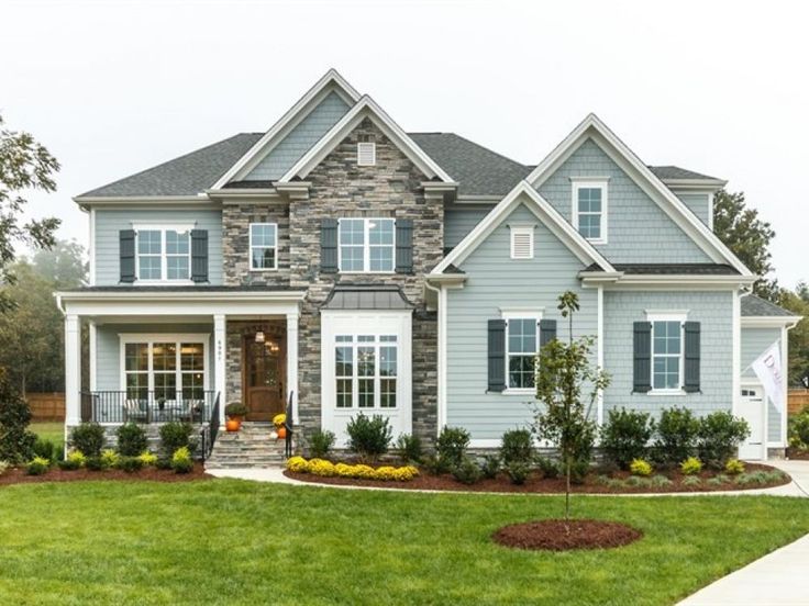 a house that is in the middle of some grass and flowers on the front lawn