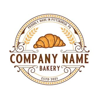 a bakery logo with a croissant in the middle and wheat sprouts around it