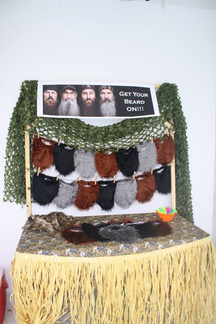 a table topped with lots of tassels next to a sign that says get your beard on it