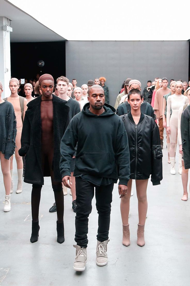 a group of men and women walking down a runway with lots of mannequins