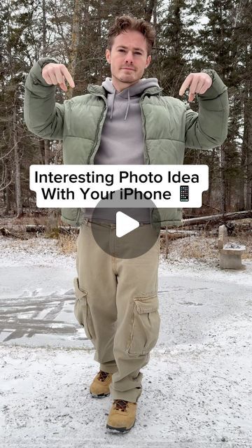 a man is standing in the snow with his hands up and pointing to the camera